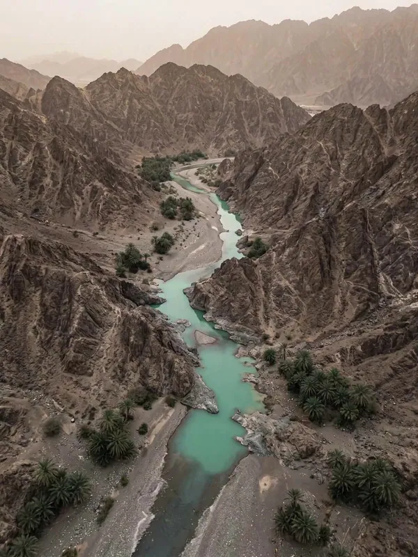 Aerial view of turquoise pools and date palms in a Hajar mountains wadi